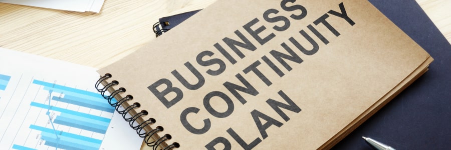 A notebook on top of a desk with business continuity plan printed on the front