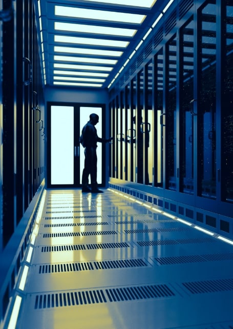 A silhouette of a man walking through a data centre